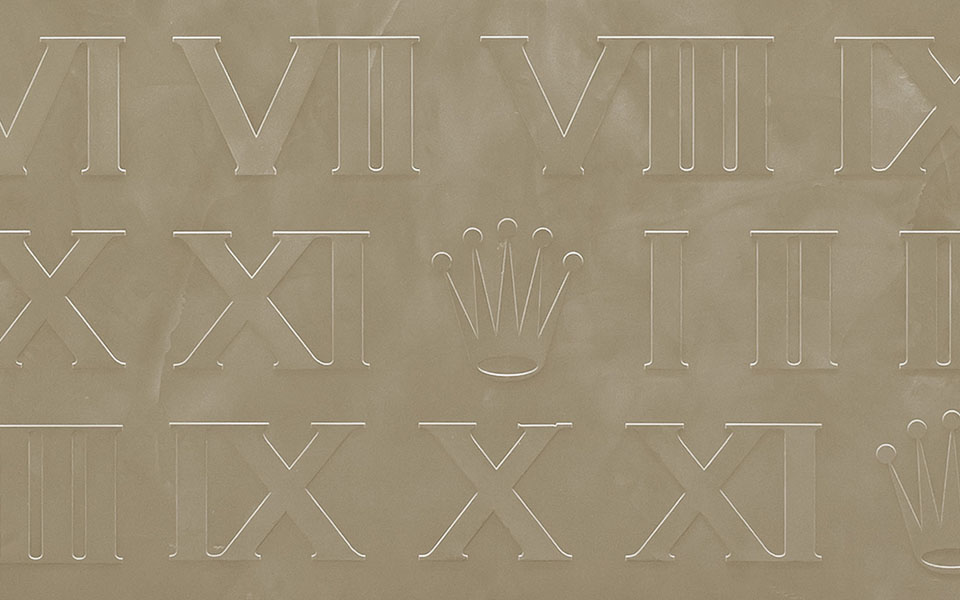 Geprägtes goldenes Bild. Drei Reihen mit römischen Ziffern. Rolex Krone in der Mitte.